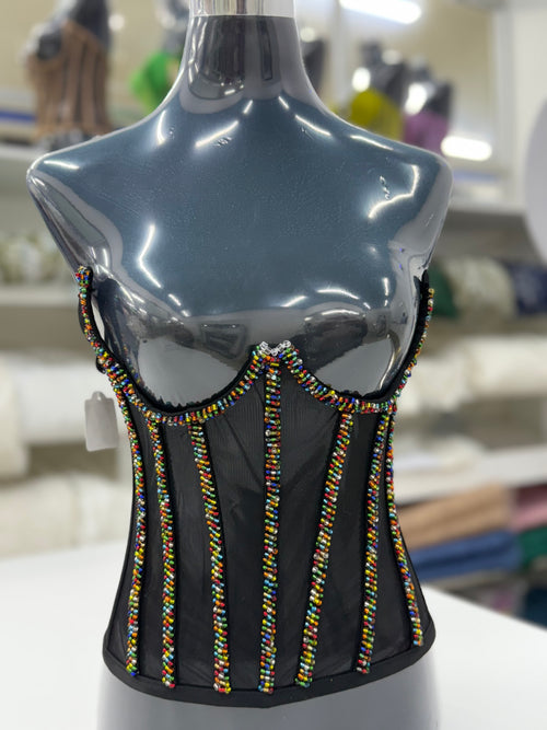 Black mesh corset adorned with vibrant African-inspired beadwork.